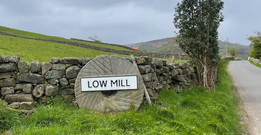A stone wall with a sign on it
Description automatically generated